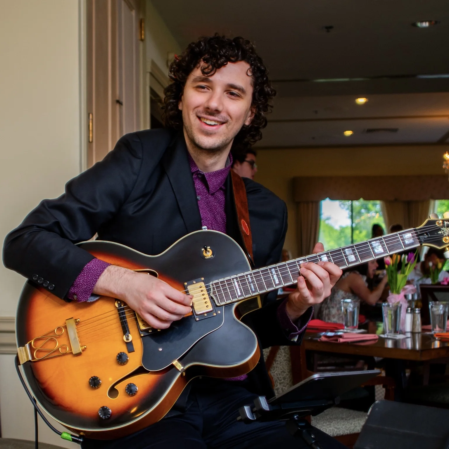 Founder Sam Burns performing on guitar